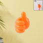 Orange hand-shaped silicone wall clip holding charging cables securely