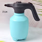 Electric garden sprayer in use, watering a plant with a fine mist.