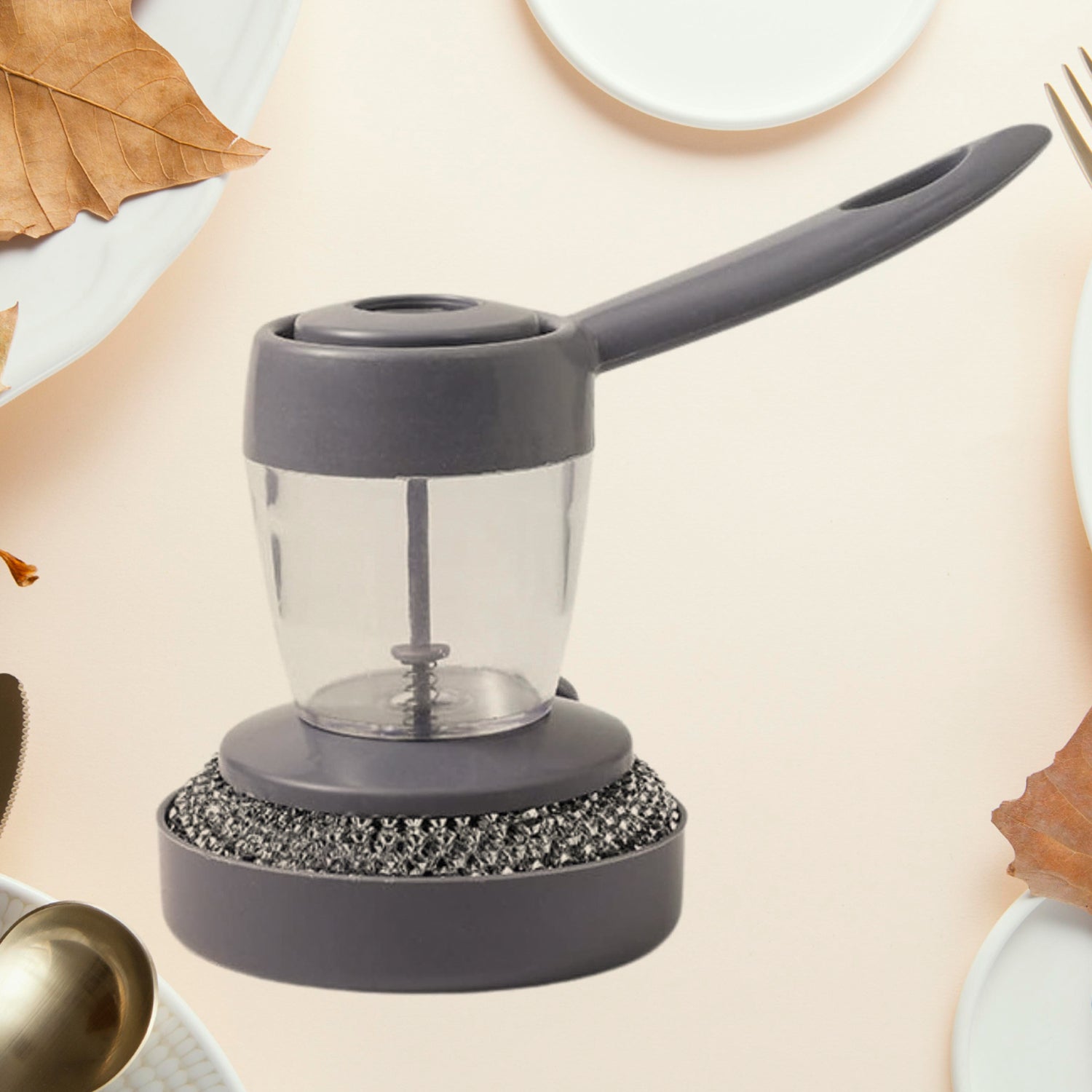 Handheld soap dispenser with integrated scrub brush cleaning a dish, showcasing ergonomic design.