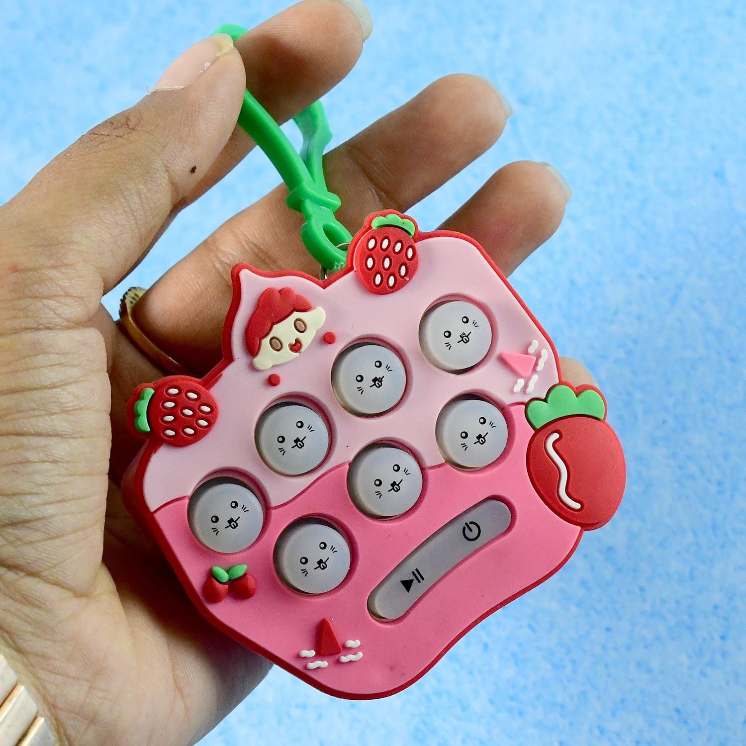 Strawberry cartoon push button keychain toy providing tactile sensory play