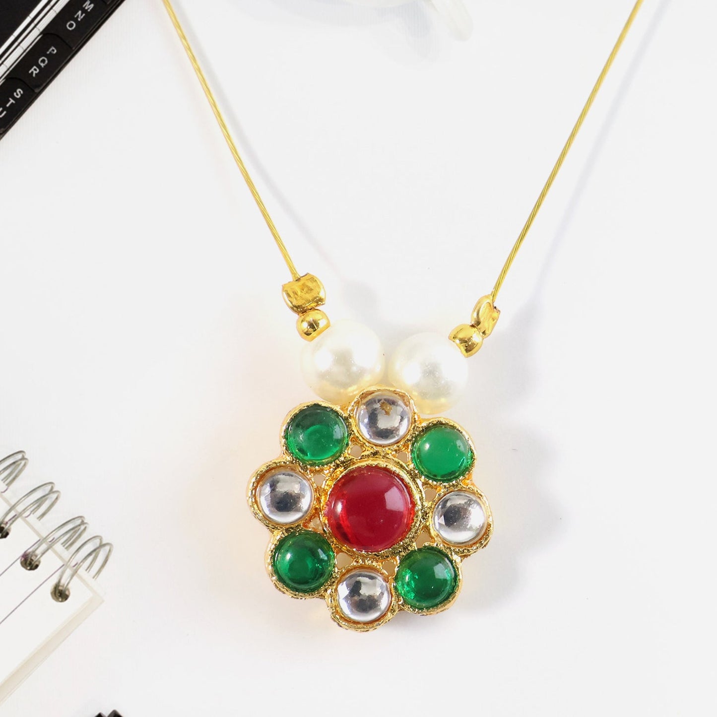 Side angle of multicolor stone floral pendant featuring pearl bead details