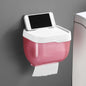 White bathroom tissue dispenser with a phone resting on its top shelf, showing its self-adhesive installation.