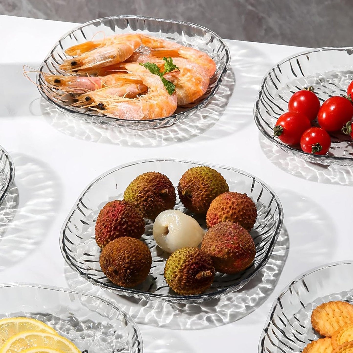 Crystal glass serving plate set showing compartments filled with fruits and snacks