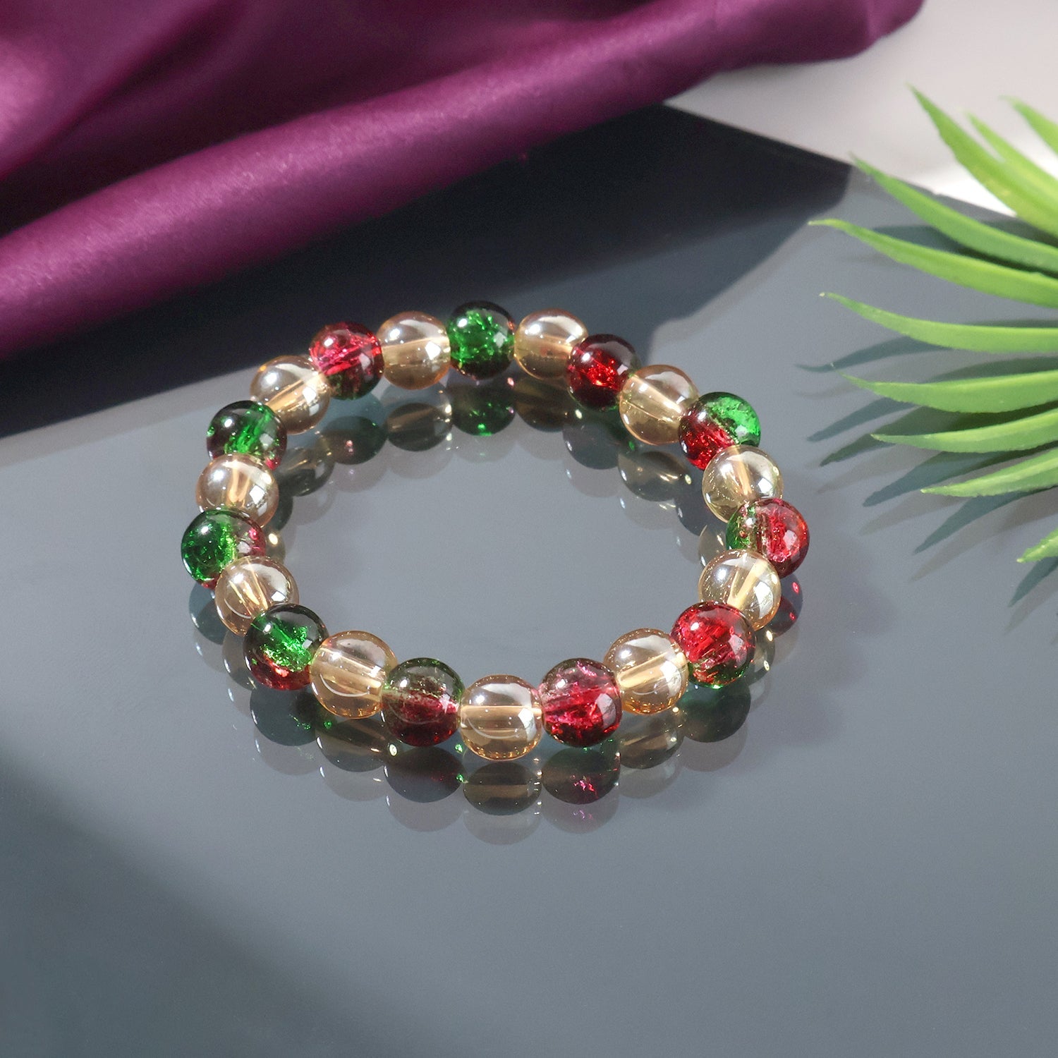 Multicolor glossy bead stretch bracelet displaying vibrant red green and golden beads
